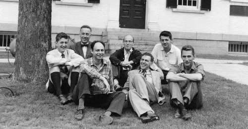 Black-and-white group photograph of seven men seated outdoors at Dartmouth College.